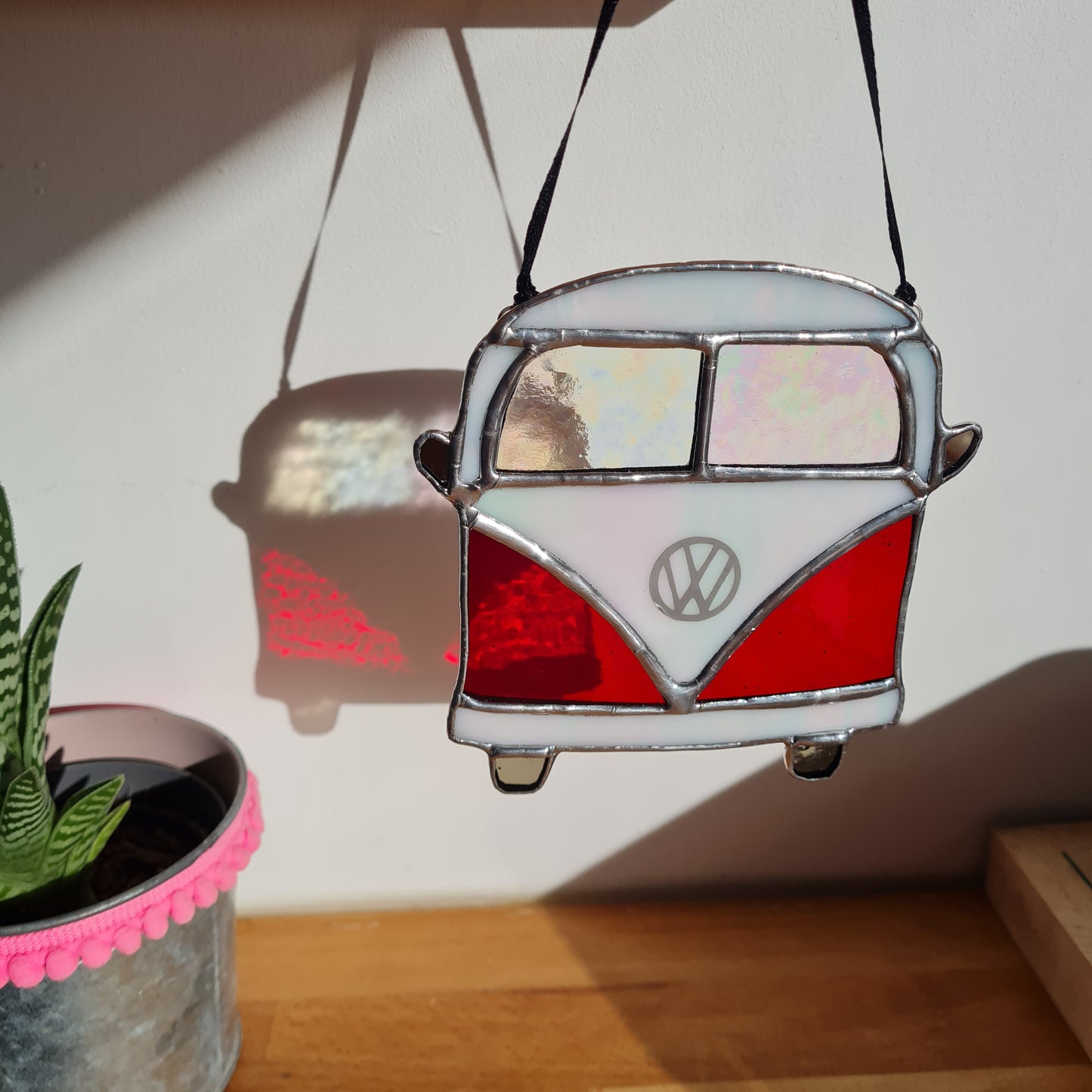 a stained glass VW camper van sucnatcher. Made with red and white stained glass